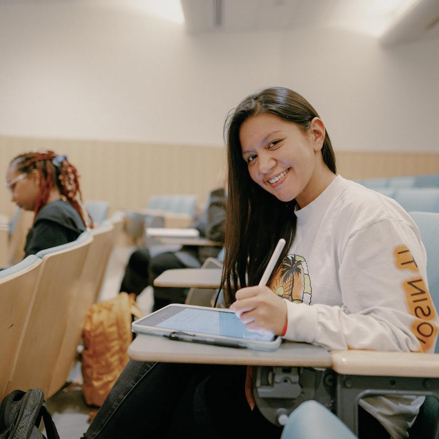 Student sitting in a classroom taking notes